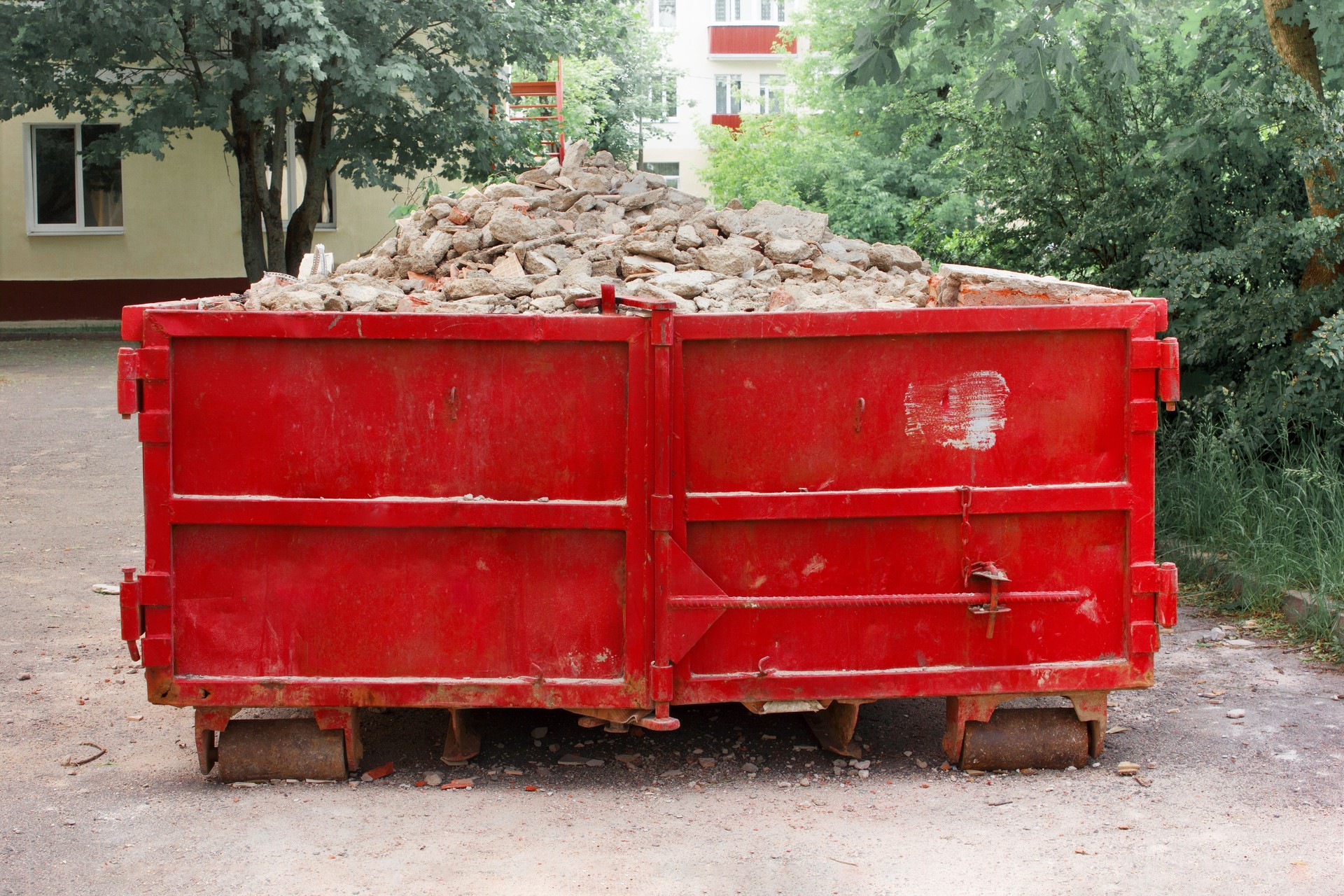 Red container with solid domestic and construction waste. Caring for the environment